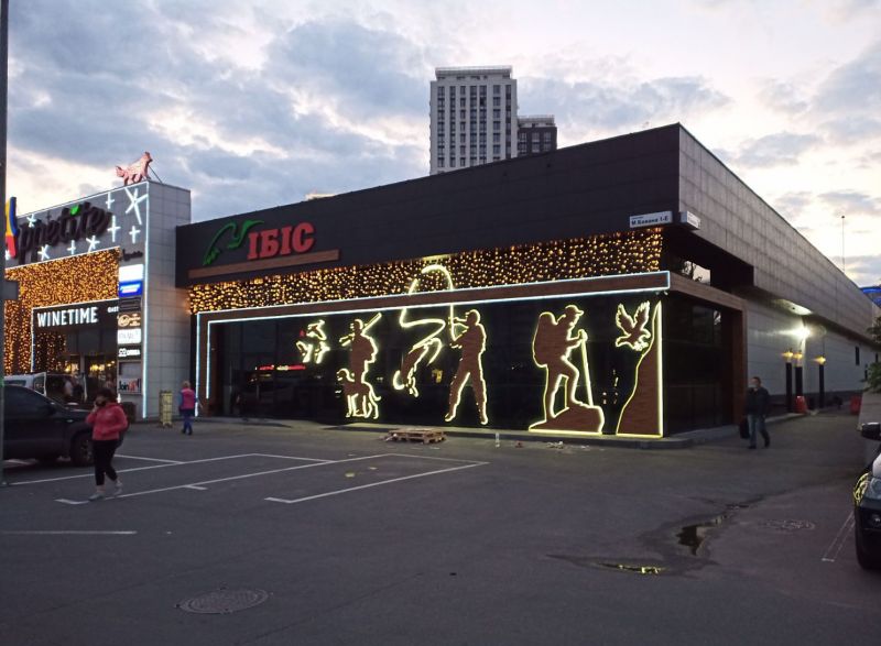 Facade sign and backlit figures Ibis